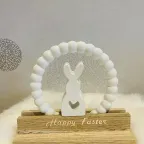 Osterhase mit Kranz auf beschrifteter Holz-Grundplatte